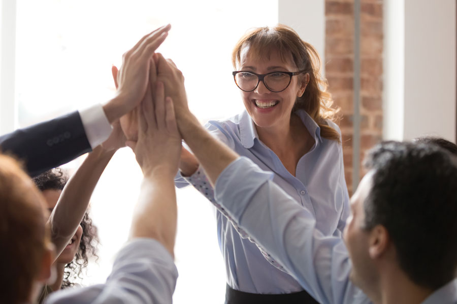 Photo of professional adults high fiving and smiling