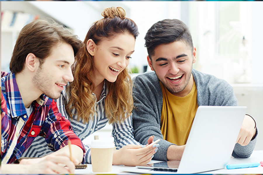 Three individuals in their 20s are looking at a computer screen