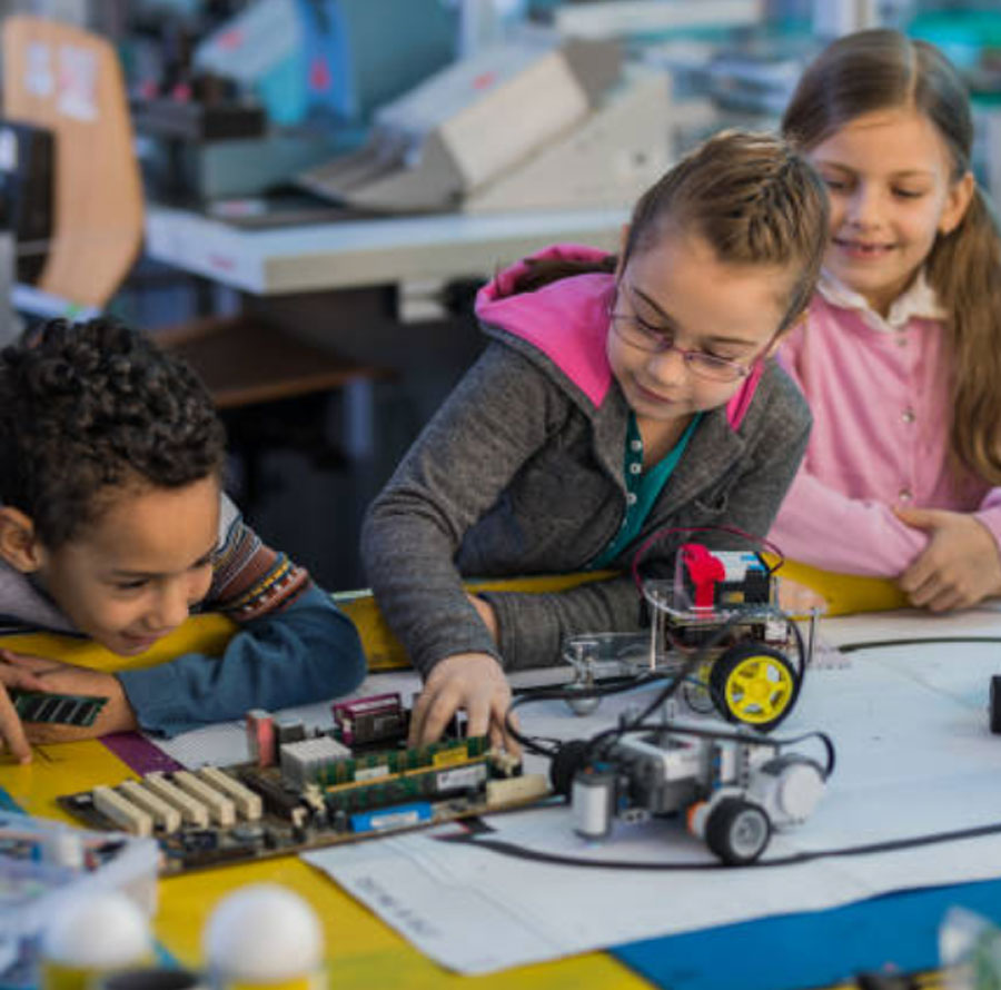 Photo of school children working on electronics and "LEGO" remote controlled components